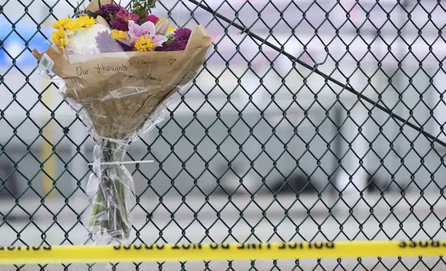 A bouquet of flowers is seen attached to a nearby fence the day after a driver killed multiple people during a Filipino community festival Sunday, April 27, 2025, in Vancouver, British Columbia. (AP Photo/Lindsey Wasson)