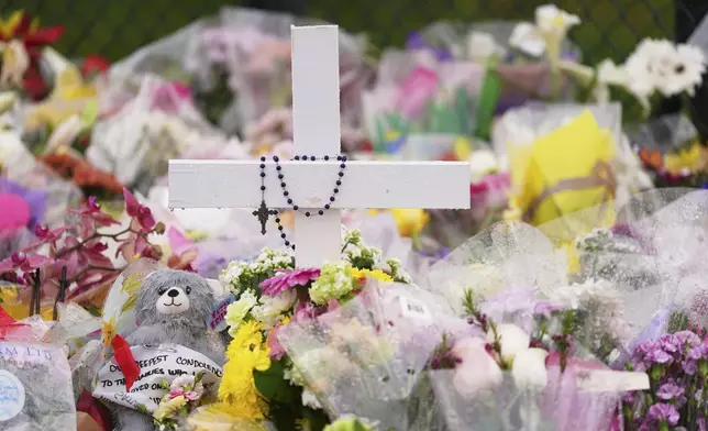 A cross stands at a memorial for victims after a vehicle drove into a crowd during a Filipino heritage festival in Vancouver, British Columbia, Monday, April 28, 2025. (AP Photo/Lindsey Wasson)