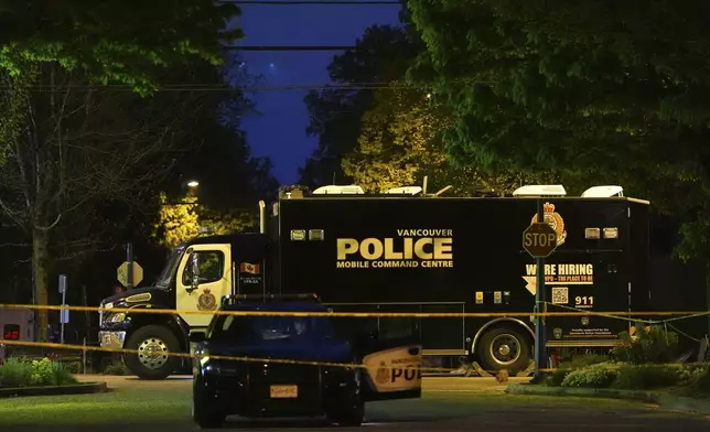 Police vehicles sit near the scene where a vehicle drove into a crowd during a Filipino heritage festival in Vancouver, British Columbia, Monday, April 28, 2025. (AP Photo/Lindsey Wasson)