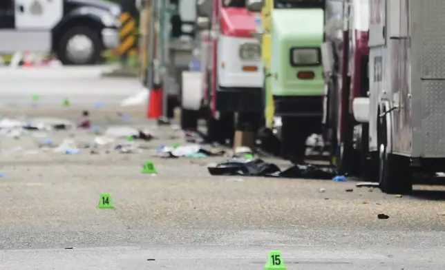 Evidence markers are seen the morning after a driver killed multiple people during a Filipino community festival, Sunday, April 27, 2025, in Vancouver, British Columbia. (AP Photo/Lindsey Wasson)