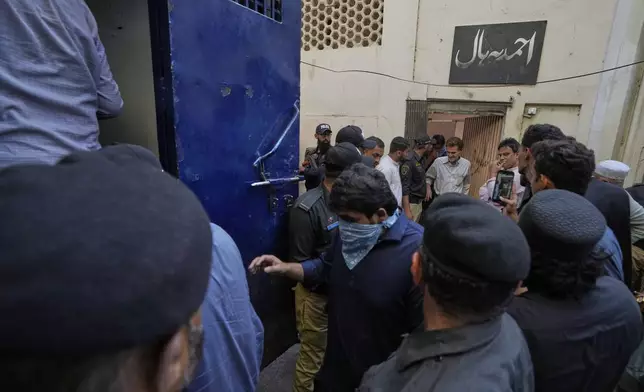Police officers rescue members of Pakistan's minority Ahmadi community from their place of worship, where supporters of Tehreek-e-Labbaik Pakistan or TLP party hold a demonstration against the Ahmadi, in Karachi, Pakistan, Friday, April 18, 2025. (AP P hoto/Fareed Khan)