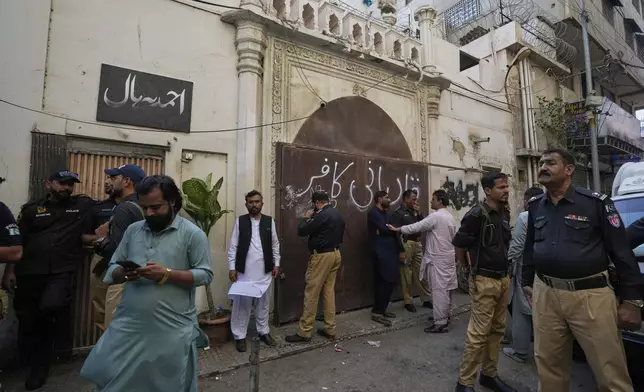 Police officers stand guard at outside the Pakistan's minority Ahmadi community's place of worship, where supporters of Tehreek-e-Labbaik Pakistan or TLP party hold a demonstration against the Ahmadi, in Karachi, Pakistan, Friday, April 18, 2025. (AP P hoto/Fareed Khan)
