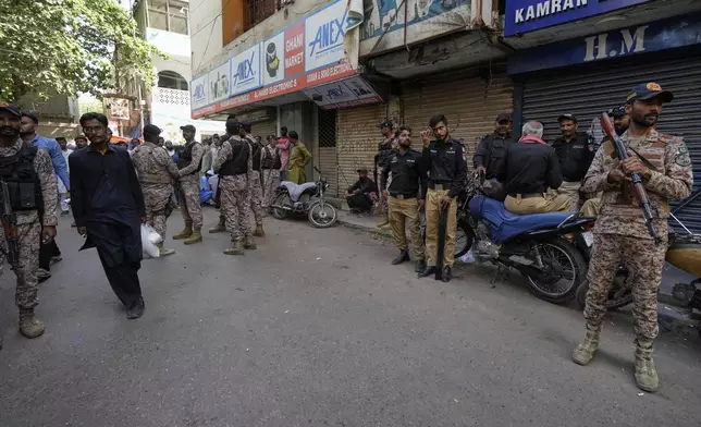 Paramilitary soldiers and police officers stand guard at outside the Pakistan's minority Ahmadi community's place of worship, where supporters of Tehreek-e-Labbaik Pakistan or TLP party hold a demonstration against the Ahmadi, in Karachi, Pakistan, Friday, April 18, 2025. (AP P hoto/Fareed Khan)