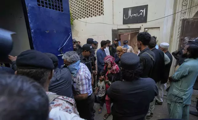 Police officers rescue members of Pakistan's minority Ahmadi community from their place of worship, where supporters of Tehreek-e-Labbaik Pakistan or TLP party hold a demonstration against the Ahmadi, in Karachi, Pakistan, Friday, April 18, 2025. (AP P hoto/Fareed Khan)