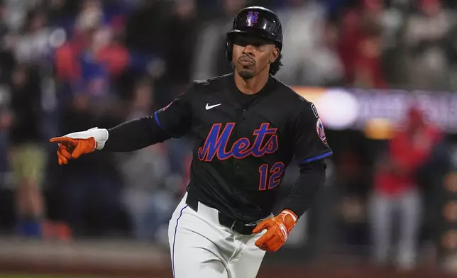 New York Mets' Francisco Lindor (12) gestures to teammates as he runs the bases after hitting a walk-off home run during the ninth inning of a baseball game against the St. Louis Cardinals Friday, April 18, 2025, in New York. (AP Photo/Frank Franklin II)