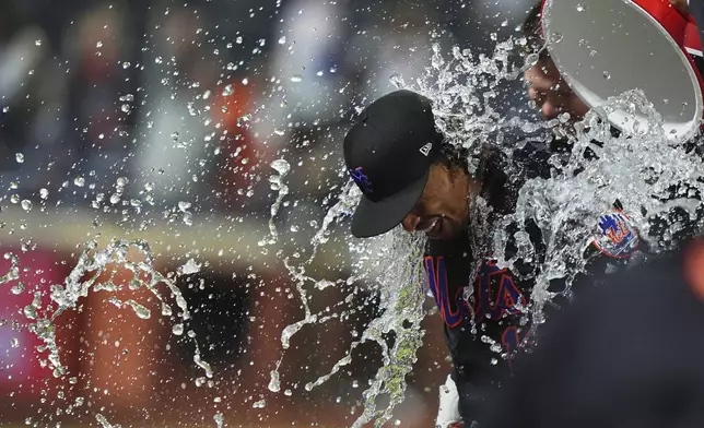 Teammates dunk water on New York Mets' Francisco Lindor after a baseball game against the St. Louis Cardinals Friday, April 18, 2025, in New York. (AP Photo/Frank Franklin II)