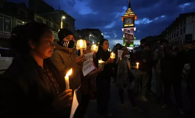 People hold candles during a candlelight protest in Srinagar, Indian controlled Kashmir, Wednesday, April 23, 2025, a day after an attack killed at least 26 people, most of them tourists. (AP Photo/Mukhtar Khan)