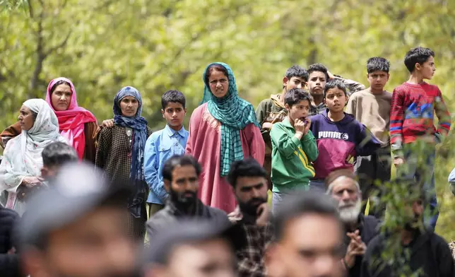 Women and children watch the funeral procession of Adil Hussain Shah, a daily-wage worker, who died when militants indiscriminately opened fire on a crowd of mainly tourists on Tuesday, at his village Hapatnar, about 20 km (13 miles) from Pahalgam where the incident took place, Indian controlled Kashmir, Wednesday, April 23, 2025. (AP Photo/Dar Yasin)