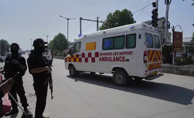 Police guard as ambulances carry bodies of tourists, in Srinagar, Indian controlled Kashmir, Wednesday, April. 23, 2025. (AP Photo/Mukhtar Khan)