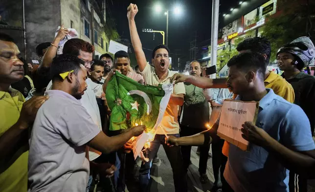 People burn a Pakistani flag in protest against the killing of tourists by militants a day after militants indiscriminately opened fire on tourists near Pahalgam in Indian controlled Kashmir, in Guwahati, India, Wednesday, April 23, 2025. (AP Photo/Anupam Nath)