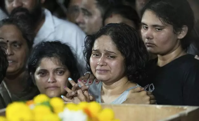 The wife of Atul Mone, who was victim in a deadly attack on tourists in the Pahalgam region of Indian-administered Kashmir, mourns as she stands near her husband's body at Dombivali near Mumbai, India, Wednesday, April. 23, 2025.(AP Photo/Rajanish Kakade)