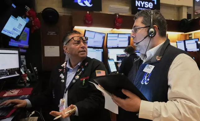 Traders Jonathan Muller, left, and Michael Capolino work on the floor of the New York Stock Exchange, Friday, April 4, 2025. (AP Photo/Richard Drew)