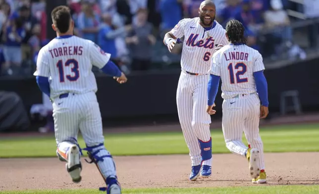 New York Mets' Starling Marte, center, celebrates with teammates after hitting a walk-off single during the tenth inning of a baseball game against the Philadelphia Phillies, Wednesday, April 23, 2025, in New York. (AP Photo/Seth Wenig)