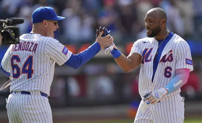 New York Mets manager Carlos Mendoza, left, celebrates with Starling Marte after he hit a walk-off RBI single in the 10th inning of a baseball game against the Philadelphia Phillies, Wednesday, April 23, 2025, in New York. (AP Photo/Seth Wenig)