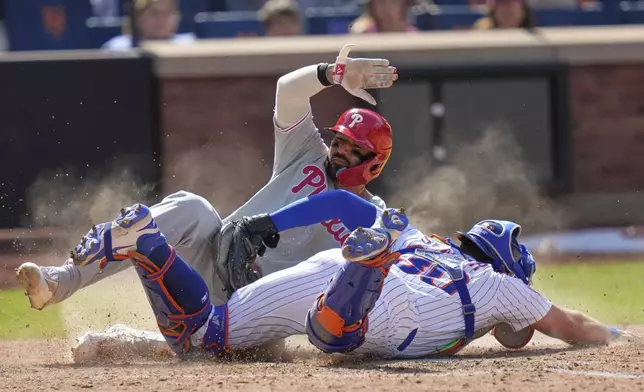 New York Mets catcher Hayden Senger, right, tags out Philadelphia Phillies' Nick Castellanos as he tries to score during the eighth inning of a baseball game, Wednesday, April 23, 2025, in New York. (AP Photo/Seth Wenig)