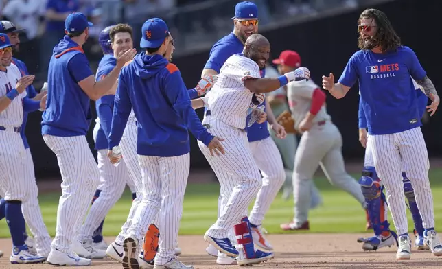 New York Mets' Starling Marte, center, celebrates with teammates after hitting a walk-off single during the tenth inning of a baseball game against the Philadelphia Phillies, Wednesday, April 23, 2025, in New York. (AP Photo/Seth Wenig)