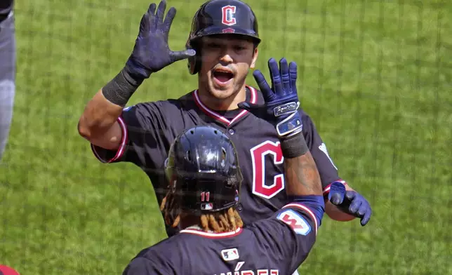 Cleveland Guardians' Steven Kwan, top, is greeted by José Ramírez as he returns to the dugout after hitting a two-run home run off Pittsburgh Pirates pitcher Mitch Keller during the third inning of a baseball game in Pittsburgh, Sunday, April 20, 2025. (AP Photo/Gene J. Puskar)
