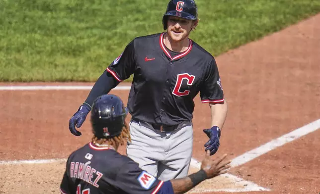 Cleveland Guardians' Kyle Manzardo, top, is greeted by José Ramírez (11) as he crosses home plate after hitting a two-run home run off Pittsburgh Pirates pitcher Joey Wentz (34) during the seventh inning of a baseball game in Pittsburgh, Sunday, April 20, 2025. (AP Photo/Gene J. Puskar)