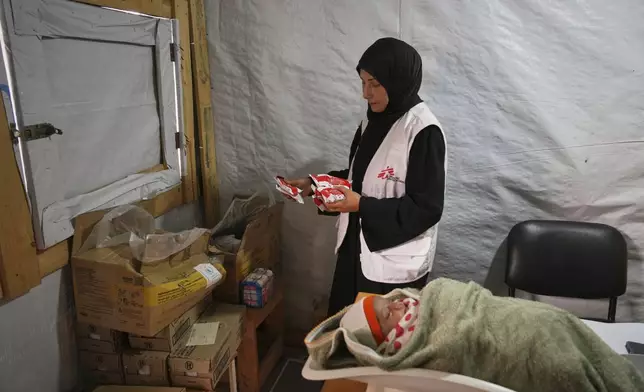 Doctors weigh a Palestinian baby at the Médecins Sans Frontières (MSF) clinic in Muwasi, near Khan Younis in the southern Gaza Strip, Wednesday, April 9, 2025. (AP Photo/Abdel Kareem Hana)
