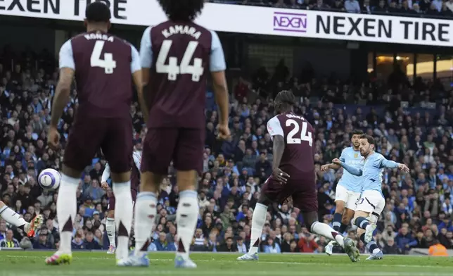 Manchester City's Bernardo Silva, right, scores his side's opening goal during the English Premier League soccer match between Manchester City and Aston Villa at Etihad stadium in Manchester, England, Tuesday, April 22, 2025. (AP Photo/Jon Super)