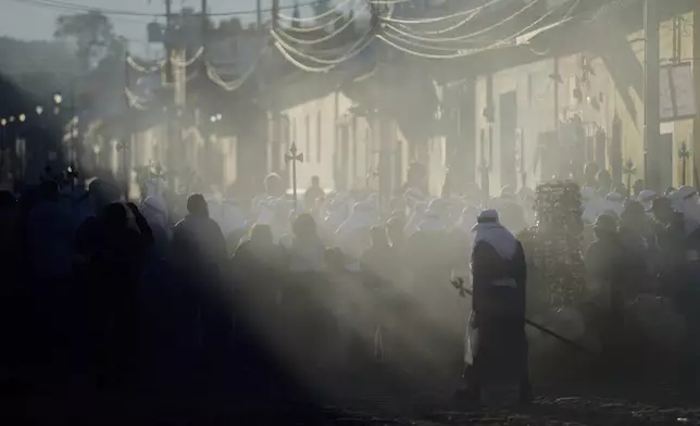 A penitent knows as a "cucurucho" joins a Way of the Cross procession during Holy Week in Antigua, Guatemala, on Good Friday, April 18, 2025. (AP Photo/Moises Castillo)