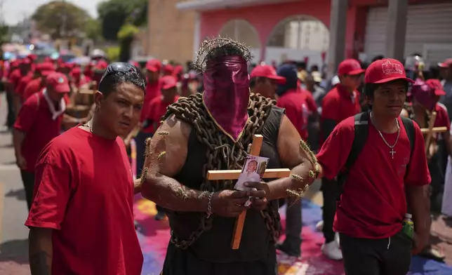 A masked penitent in chains with cacti attached to his arms takes part in a Holy Week procession in Atlixco, Mexico, on Good Friday, April 18, 2025. (AP Photo/Eduardo Verdugo)