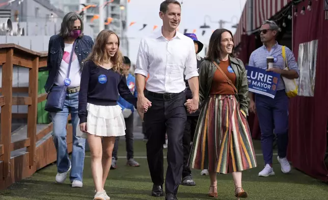 FILE - San Francisco mayoral candidate Daniel Lurie, middle, walks with his daughter Taya Lurie, foreground left, and his wife, Becca Prowda, foreground right, while campaigning in San Francisco, Saturday, Oct. 26, 2024. (AP Photo/Jeff Chiu, File)
