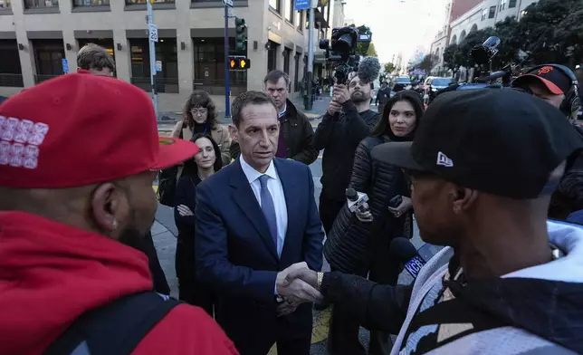 Mayor-elect Daniel Lurie, center, speaks with people in the Tenderloin neighborhood Wednesday, Jan. 8, 2025, in San Francisco. (AP Photo/Godofredo A. Vásquez)