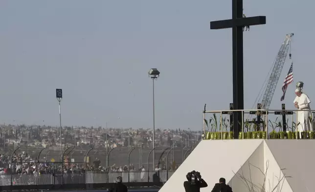 FILE— Hundreds of people gather on the U.S. side of the border to watch as Pope Francis prays at the U.S.-Mexico border fence along the Rio Grande, in Ciudad Juarez, Mexico, Feb. 17, 2016. (AP Photo/Gregorio Borgia, File)