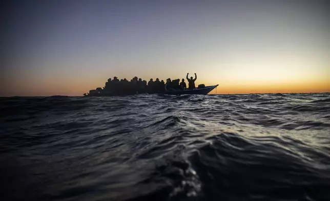 FILE - Migrants and refugees wait for assistance on an overcrowded wooden boat in the Mediterranean Sea off the Libyan coast, Feb. 12, 2021. (AP Photo/Bruno Thevenin, File)