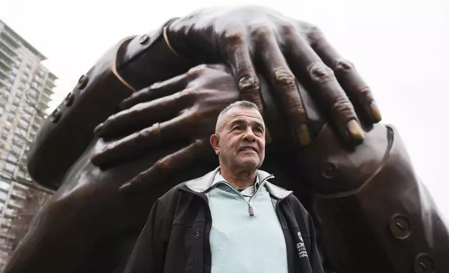 Wayne Lucas, who sixty years ago participated at the Freedom Rally on Boston Common, poses at the "The Embrace" sculpture on the common, Tuesday, April 15, 2025, in Boston. (AP Photo/Charles Krupa)