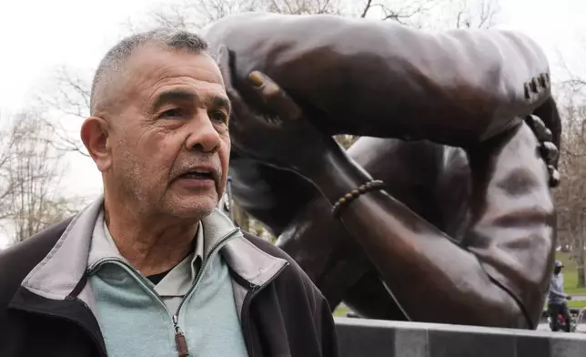 Wayne Lucas, who sixty years ago participated at the Freedom Rally on Boston Common, is interviewed at the "The Embrace" sculpture on the common, Tuesday, April 15, 2025, in Boston. (AP Photo/Charles Krupa)