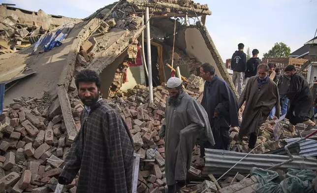Kashmiri villager inspect the debris of the blown-up family home of Ahsan Ul Haq Shiekh, a militant who officials say is involved in the deadly attack on tourists in Pahalgam, at Murran village in Pulwama, south of Srinagar, Indian controlled Kashmir, Saturday, April 26, 2025. (AP Photo/Dar Yasin)