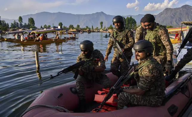 Paramilitary soldiers board a patrol boat as Indian tourists take boat rides on Dal Lake in Srinagar, Indian controlled Kashmir, Friday, April 25, 2025. (AP Photo/Dar Yasin)