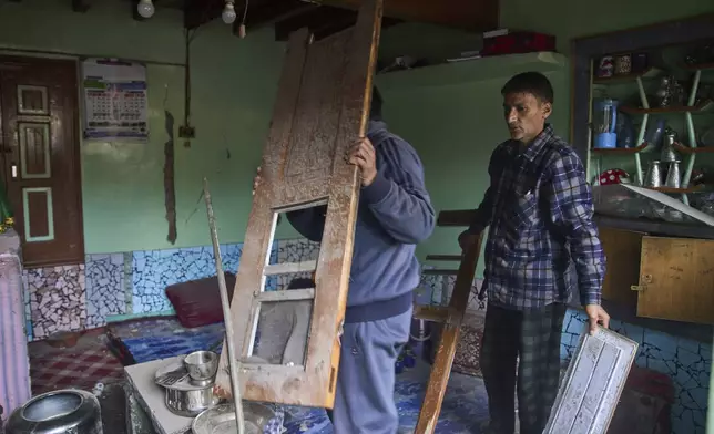 Kashmiri men salvage items in a neighbouring house after Indian forces blew up the family home of Ahsan Ul Haq Shiekh, a militant who officials say is involved in the deadly attack on tourists in Pahalgam, at Murran village in Pulwama, south of Srinagar, Indian controlled Kashmir, Saturday, April 26, 2025. (AP Photo/Dar Yasin)