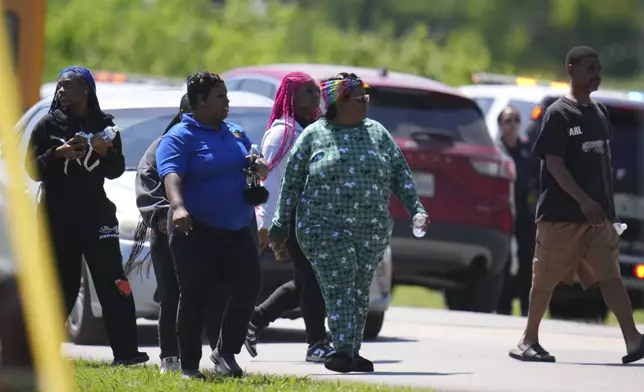 Parents arrive to pick up their children at Wilmer-Hutchins High School, where police are responded to reports of a shooting in Dallas, Tx., Tuesday, April 15, 2025. (AP Photo/Julio Cortez)