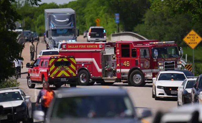 A fire engine blocks a road accessing Wilmer-Hutchins High School, where police are responding to reports of a shooting, in Dallas, Tx., Tuesday, April 15, 2025. (AP Photo/Julio Cortez)