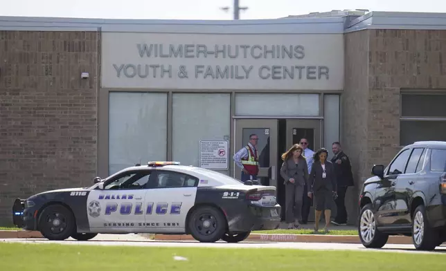 Superintendent Stephanie Elizalde, left center, exits the Wilmer-Hutchins High School youth and family center after authorities reported the campus had been secured following reports of a shooting, in Dallas, Tx., Tuesday, April 15, 2025. (AP Photo/Julio Cortez)