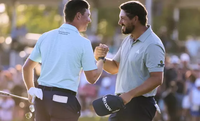 Andrew Novak, right, embraces teammate Ben Griffin on the 18th green after they won the PGA Zurich Classic golf tournament at TPC Louisiana in Avondale, La., Sunday, April 27, 2025. (AP Photo/Gerald Herbert)