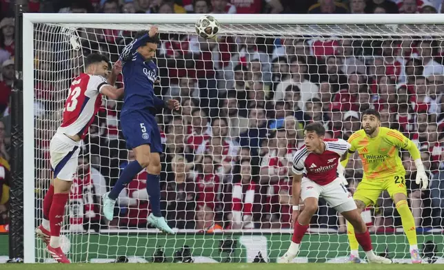 Arsenal's goalkeeper David Raya watches as PSG's Marquinhos, 2nd left, attempts a header during the Champions League semifinal first leg soccer match between Arsenal and Paris Saint-Germain at Arsenal Stadium in London, England, Tuesday, April 29, 2025. (AP Photo/Kin Cheung)