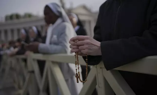 A nun holds a rosary as she waits for the funeral of Pope Francis to begin, in St. Peter's Square at the Vatican, Saturday, April 26, 2025. (AP Photo/Emilio Morenatti)