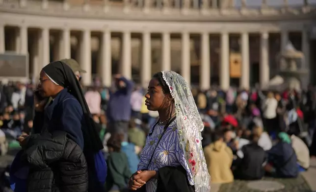 People wait for the funeral of Pope Francis in St. Peter's Square at the Vatican, Saturday, April 26, 2025. (AP Photo/Andreea Alexandru)