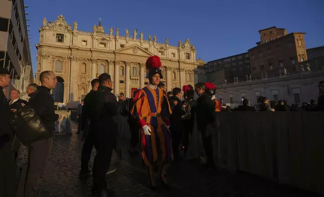Faithful and Swiss Guards are backdropped by St. Peter's Basilica ahead of the funeral of Pope Francis in St. Peter's Square at the Vatican, Saturday, April 26, 2025. (AP Photo/Alessandra Tarantino)