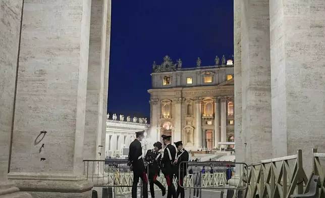 Police officers speak in St. Peter's Square ahead of the funeral of Pope Francis at the Vatican, Saturday, April 26, 2025. (AP Photo/Andreea Alexandru)