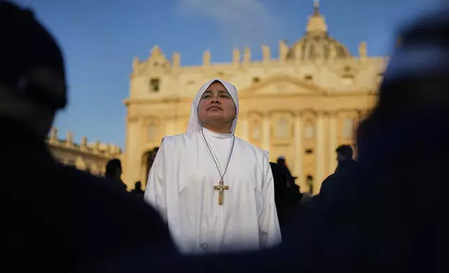 A nun waits in St. Peter's Square as people arrive ahead of the funeral of Pope Francis at the Vatican, Saturday, April 26, 2025. (AP Photo/Andreea Alexandru)