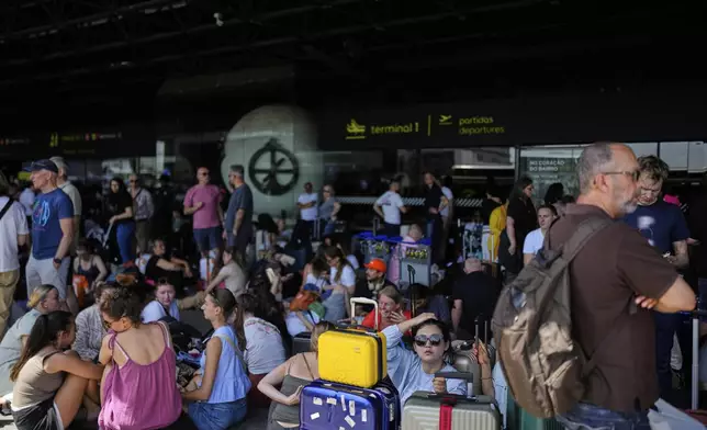 Passengers wait outside Lisbon Airport during a nationwide power outage in Lisbon, Monday, April 28, 2025. (AP Photo/Armando Franca)