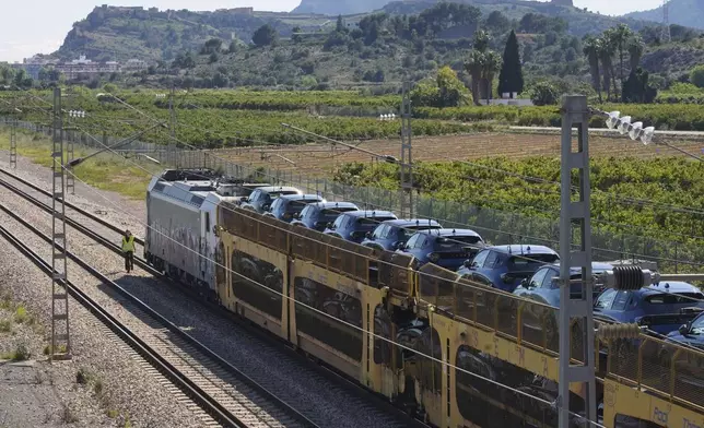 A freight train loaded with cars is stopped on the track during a nationwide power outage near Sagunto, eastern Spain, Monday, April 28, 2025. (AP Photo/Alberto Saiz)
