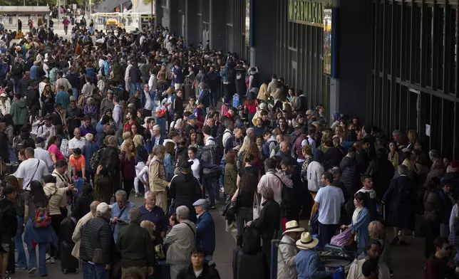 People wait outside a closed train station, during a major power outage in Barcelona, Spain, Monday, April 28, 2025. (AP Photo/Emilio Morenatti)