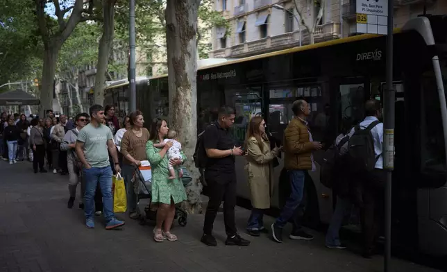 People board a bus, during a major power outage in Barcelona, Spain, Monday, April 28, 2025. (AP Photo/Emilio Morenatti)