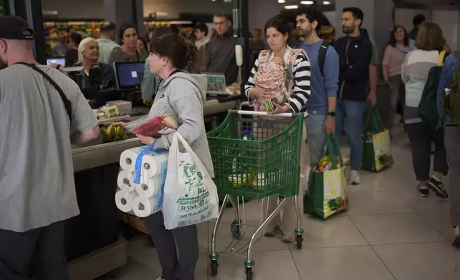 People buy food at a supermarket, during a major power outage in Barcelona, Spain, Monday, April 28, 2025. (AP Photo/Emilio Morenatti)
